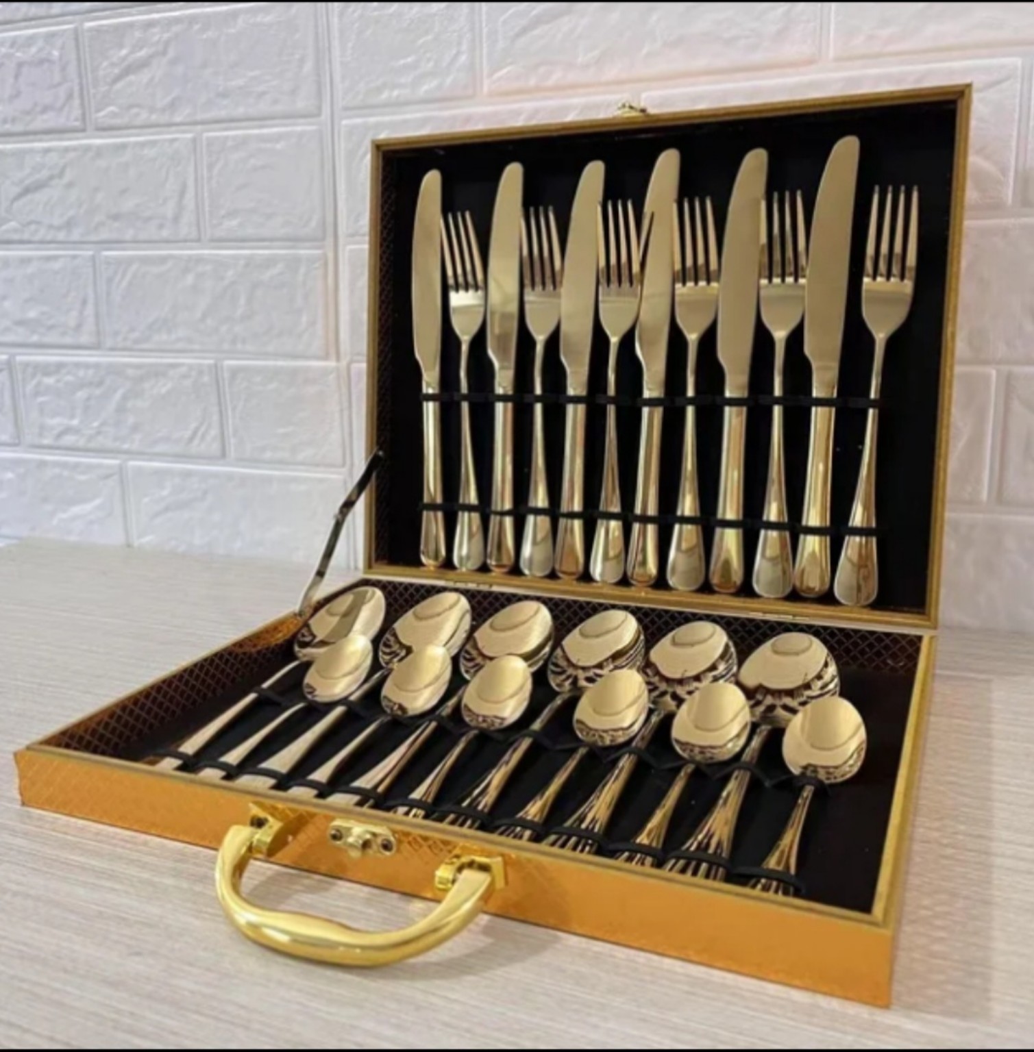 Twenty-four-piece mirror gold stainless steel cutlery set arranged in a gold gift case